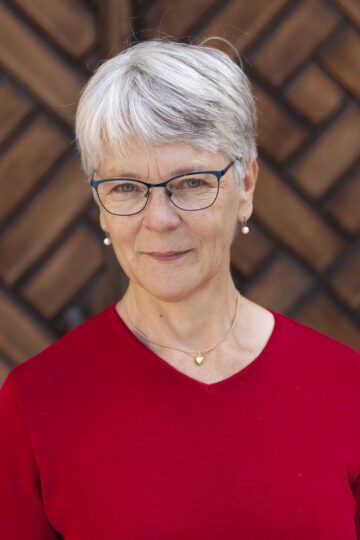 Porträttfoto av Anna Richert framför en stor trädörr.