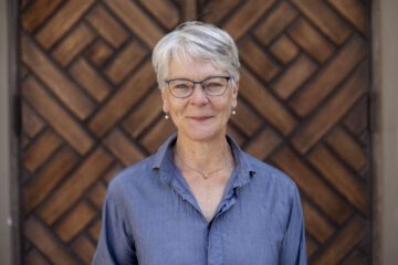 Porträttfoto av Anna Richert framför en stor trädörr.