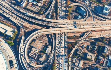 En fågelperspektiv över en komplex motorvägsanslutning i Los Angeles, med många bilar som rör sig i olika riktningar.