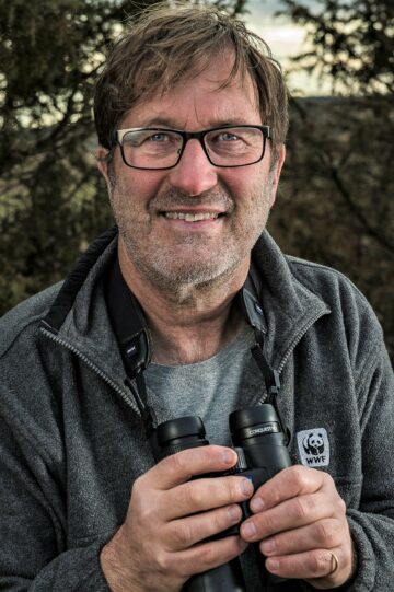 Ola Jennersten, global naturvårdsexpert på WWF, håller kikare; bär fleecetröja med patch "WWF".