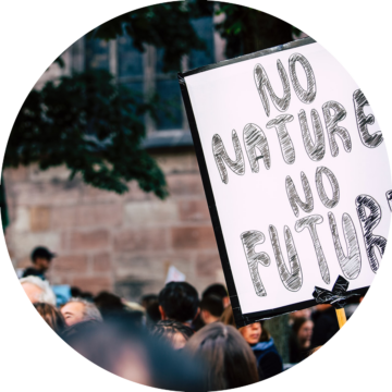 Rund bild: Skylt med texten "NO NATURE NO FUTURE" hålls upp i folkmassa under demonstration.