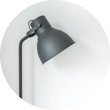 Rund bild: Svart, justerbar golvlampa med rund skärm, vinklad ljusriktningsinställning, monterad på rak stång.