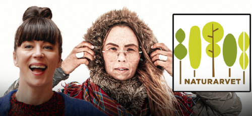 En kvinna klädd i varma, pälsliknande kläder med huva, håller i huvans kanter med båda händerna. Till vänster syns en Isabelle Mcallister från axlarna och uppåt, med blå kofta och mörkbrunt hår i knut.