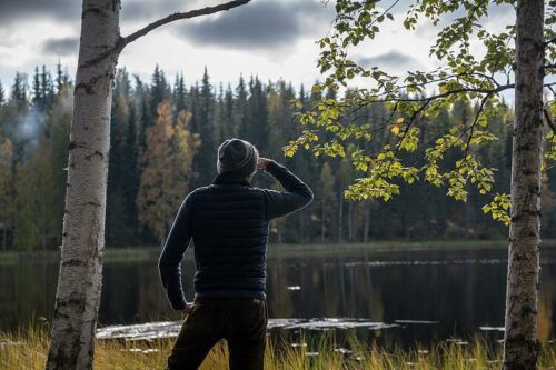 Person som spejar ut över en sjö i skogen.