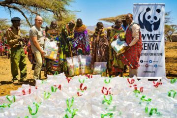 Människor samlade framför matpaket från WWF