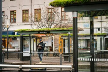 En man står och väntar vid en busskur