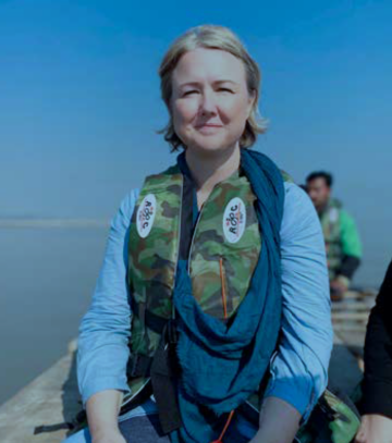 Foto av biolog Stina Nyström från WWF bär en flytväst och sitter i en båt på Indusfloden i Pakistan.