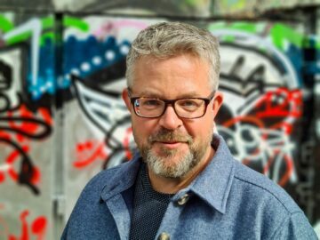 Porträtt av Mattias framför grafittimålad vägg