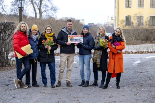 Sju personer från Postkodlotteriet, Nordens Ark och WWF ler med en check.