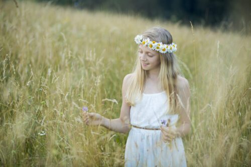 MIDSOMMAR Flicka med midsommarkrans av prästkragar