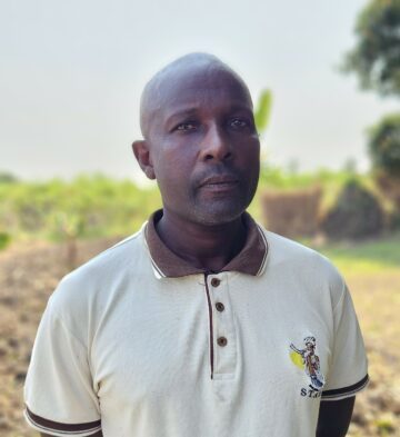 Nbs, Moçambique. Porträtt bild av man i vit t-shirt.