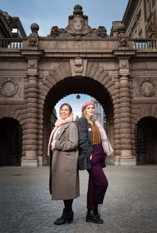 SoxboSundh-223-R-Eko1-26 Maria Soxbo och Emma Sundh, grundare av Klimatklubben. De står rygg mot rygg, med byggnaden till Sveriges riksdag bakom sig.