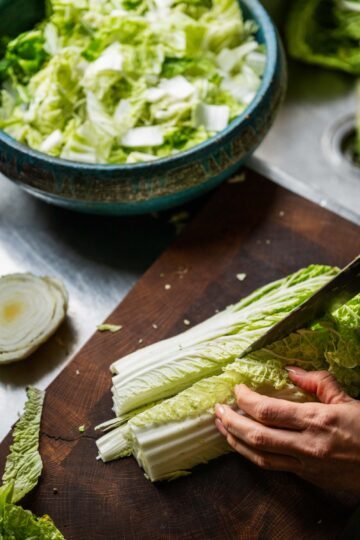 Händer som skär i sallad.