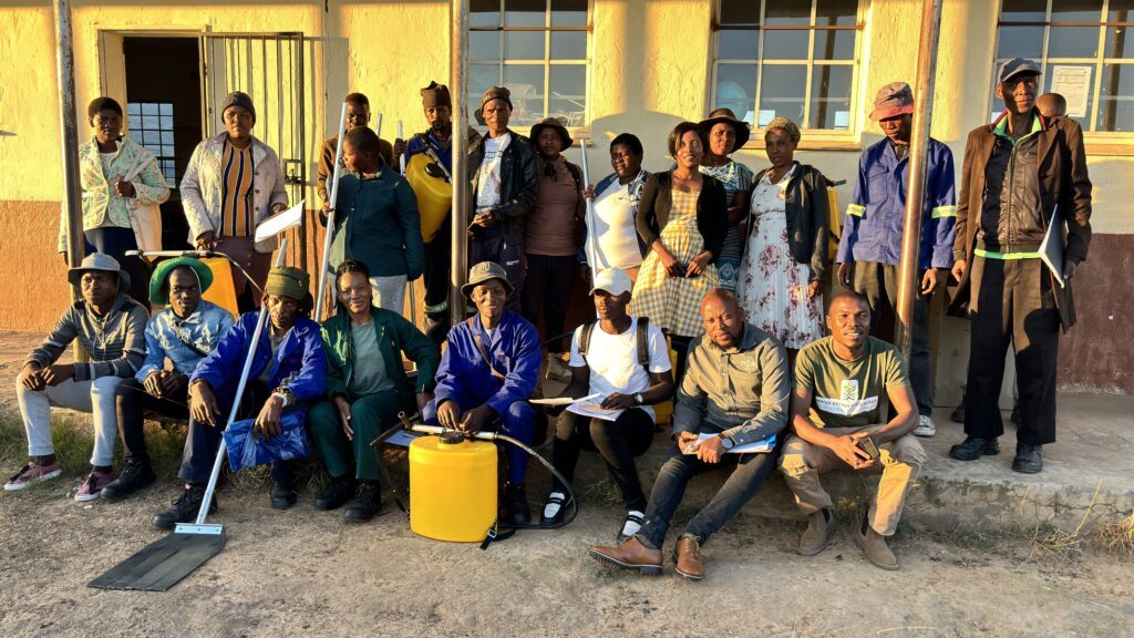 Community members receiving training in firefighting techniques. The gentleman at the front holds a fire beater provided